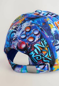 Cappello da baseball con un vivace design di graffiti multicolori e tessuto testurizzato. Include una fibbia metallica argentata su un cinturino regolabile.