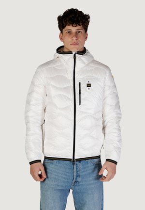 Giacca bianca trapuntata con zip frontale, cappuccio e dettagli neri. Presenta una tasca sul petto con zip e polsini a coste con strisce verdi e gialle.