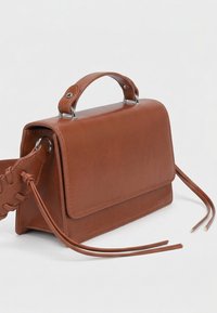 Sac bandoulière en cuir marron avec poignée supérieure, fermeture à rabat et longues lanières tressées et lisses sur fond blanc.