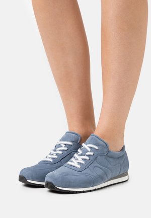 Sneaker in suede di un azzurro chiaro con dettagli testurizzati. Presentano lacci bianchi e una suola in gomma nera con una striscia bianca.