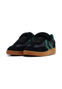 Sneaker neri e verdi con suole in gomma, tomaia in mesh e suede, lacci e una singola fascia in Velcro sopra.