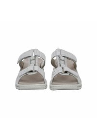 White sandals with textured straps and adjustable closures. The sole features a light cushioning and a contrasting white trim.