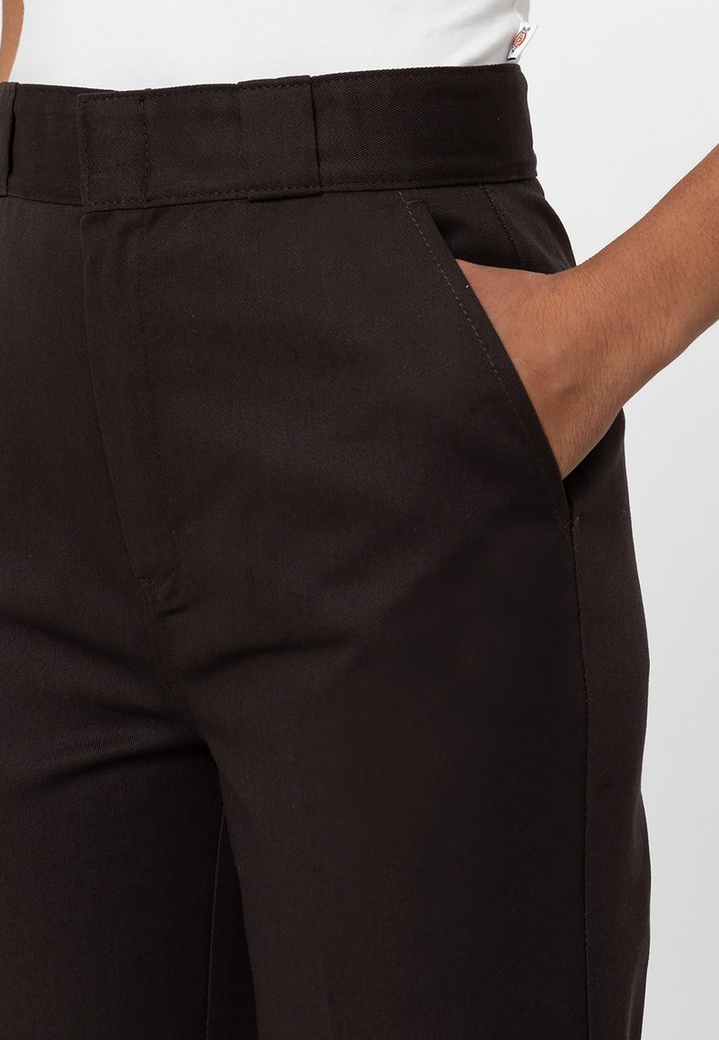 Pantalones negros con una textura suave, que presentan bolsillos y un diseño de piernas rectas. La cintura es resistente y ligeramente texturizada.