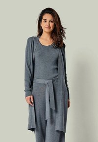 Graues Strick-Loungewear-Set mit einem langen Cardigan und einem taillierten Tanktop, ergänzt durch passende Hose mit Bindegürtel und einer weichen Textur.
