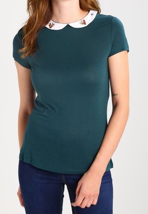 Camiseta verde azulado de manga corta y cuello blanco con bordado floral. Ajuste ceñido, con una textura suave y lisa.