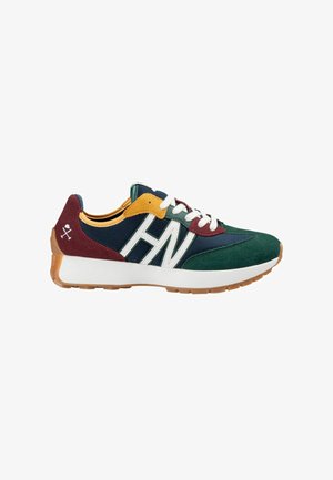 Zapatilla deportiva con parte superior de malla verde y marino, acentos en burdeos y mostaza, logo blanco y suela de goma texturizada color caramelo.