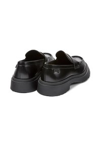 Pair of black leather slip-on loafers with thick rubber soles, viewed from the back on a white background.