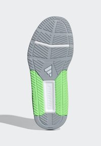 Shoe sole featuring a gray rubber surface with a textured pattern. Green accents on sides and a white central section with "REPETITOR" embossed.