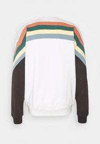 Felpa bianca con accenti multicolori a strisce arancioni, verdi, gialle e blu sulle spalle. Presenta maniche lunghe nere.