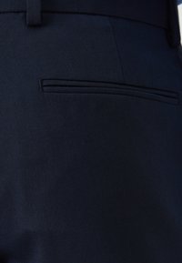 Ναυτικού μπλε παντελόνι με υφασμάτινη υφή. Διαθέτει επίπεδο μπροστά και διακριτική, στενή πίσω τσέπη. Ραμμένο με κομψές λεπτομέρειες.