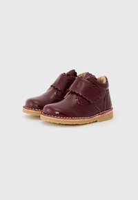 Sapatos infantis em couro bordô com design escamado, tiras de Velcro e sola de borracha bege. Textura suave com acabamento polido.