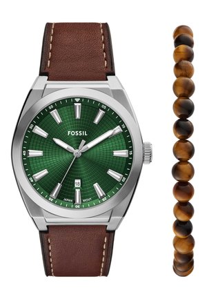 Montre Fossil avec un cadran à motif vert, des aiguilles argentées et un bracelet en cuir marron. Comprend un bracelet compagnon en perles de verre tigre marron poli.