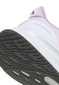 Chaussure de sport avec une tige en mesh blanc et violet clair, une semelle en caoutchouc texturée et une semelle extérieure principalement noire avec des rainures d'adhérence.
