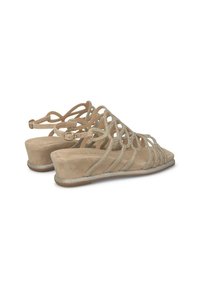 Sandales compensées beiges avec un dessus en daim texturé, ornées de découpes décoratives et d'accents scintillants, maintenues par une sangle à boucle.
