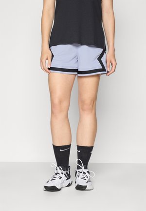 Shorts atletici de culoare azulie deschis, cu borduri și detalii laterale negre, asortați cu sosete negre și pantofi albi. Material texturat, croi lejer.