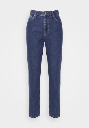 Temno modri traper jeans s ravnim krojem, petimi žepi, vidnimi šivi in kovinskim gumbom za zapiranje v pasu.