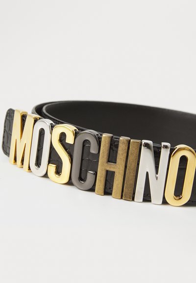 Čierny kožený opasok so metalickými písmenami, ktoré píšu "MOSCHINO" v zlatej, striebornej a gunmetalovej farbe, s textúrovaným vzorom.