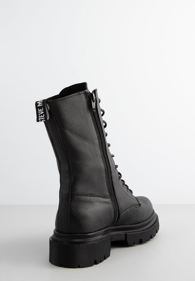 Czarne skórzane botki za kostkę z masywną podeszwą, sznurowanym przodem i bocznym zamkiem. Posiadają materiałową pętelkę z logo na tyle.