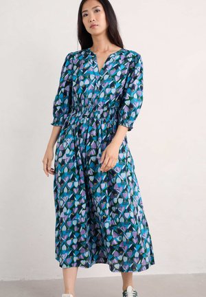 Blumendruckkleid in Blau- und lila Tönen, mit V-Ausschnitt, 3/4 Puffärmeln und einem elastischen Taillenbund. Mittellang mit einem fließenden Rock.