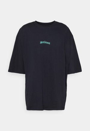 T-shirt noir ample à manches courtes avec un texte gothique turquoise "Unreleased" centré sur la poitrine sur un fond blanc.