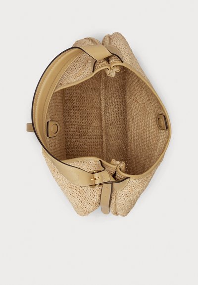 Μπέζ τσάντα από πλεκτό άχυρο με ευρύ δερμάτινο λουρί, κλείσιμο με πόρπη και μαγνητικά κουμπώματα, εμφανιζόμενη από πάνω προς τα κάτω.