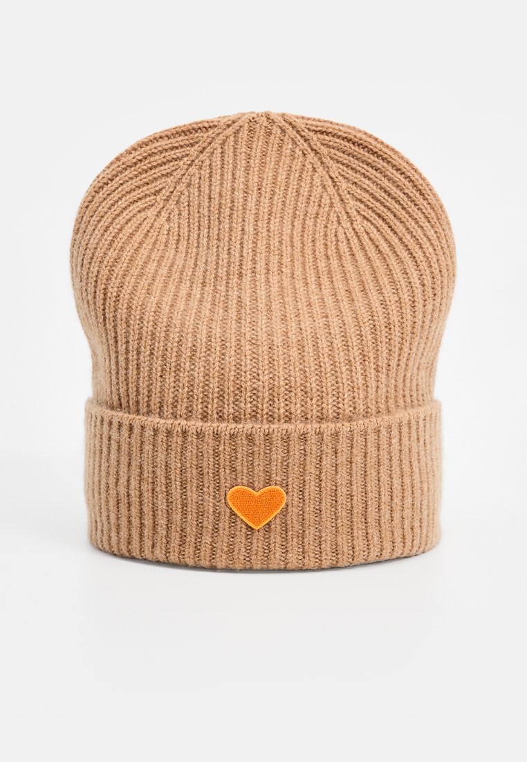 Jasnobrązowa dzianinowa czapka z prążkowanego materiału z podwiniętym brzegiem, z małą pomarańczową łatą w kształcie serca na frontowej części.