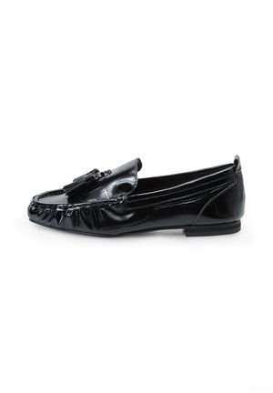 Mocasines de cuero negro con punta redondeada, que presentan un borlas decorativa y detalles fruncidos en la parte frontal, y una suela plana de goma.