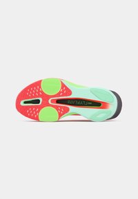 Podeszwa buta Nike ma miętowozieloną bazę z czerwonymi i wzorzystymi akcentami, teksturowaną dla lepszego uchwytu, oraz czarną część pięty z logo marki.