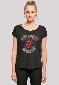 Zwarte katoenen T-shirt met een ronde hals en opgerolde korte mouwen, met een bedrukt rood Rolling Stones-logo.