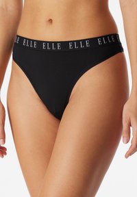 Mustat puuvillaiset stringit, joissa on logolla varustettu vyötärönauha. Kangas näyttää sileältä, ja siinä on tyylikäs viimeistely sekä minimalistinen muotoilu.