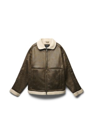 Brązowa kurtka z sztucznej skóry z kremowym kołnierzem i mankietami z owczej wełny; posiada zamek błyskawiczny z przodu oraz pudełkowy krój z widocznymi szwami.
