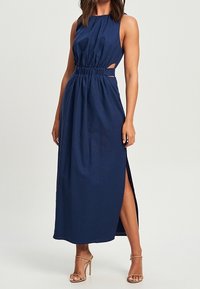 Granatowa długa sukienka maxi bez rękawów, z wcięciem w talii, bocznymi wycięciami i wysokim rozcięciem. Gładki materiał o luźnym kroju.