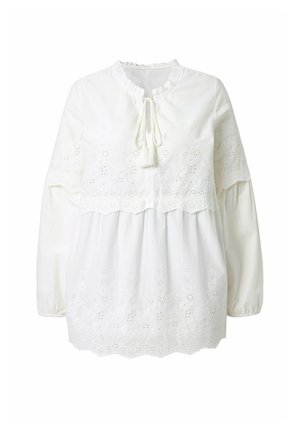 Blusa blanca de manga larga con recortes florales bordados, escote con volantes, cierre con lazo y dobladillo festoneado en las mangas y la parte inferior.