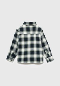 Flanellipaita pitkillä hihoilla, musta-valkoinen ruutukuosi, kauluksellinen muotoilu, nappikädentiet, pehmeä rakenne, takakappaleen yksityiskohta.