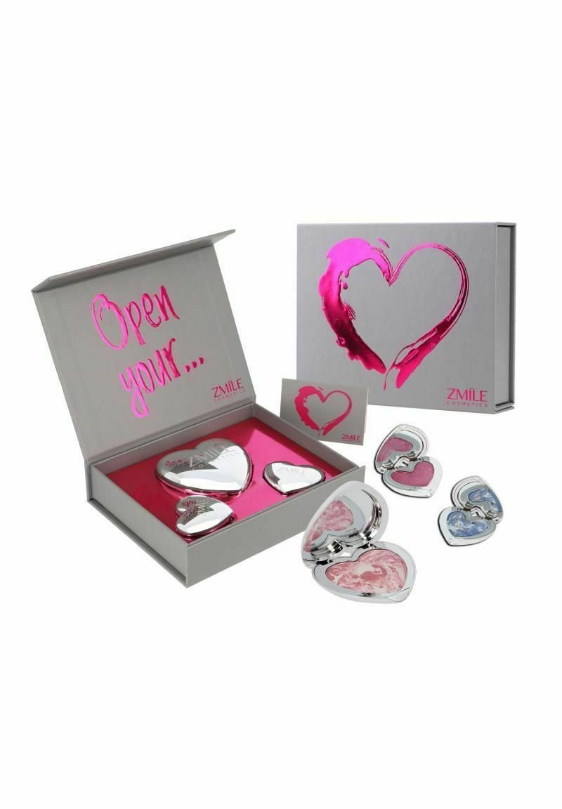 Set av hjärtformade speglar i silvermetall med rosa accenter, presenterade i en grå låda med ett magenta hjärtdesign och rosa inredning.