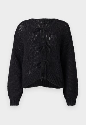 Maglione nero lavorato a maglia con una vestibilità ampia, chiusura anteriore con nastro e orlo a coste. Il tessuto testurizzato e le maniche a palloncino aggiungono dimensione.