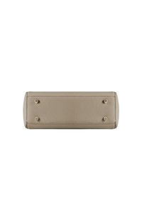 Vista inferior de un bolso de mano de cuero beige texturizado con cuatro patas redondas de metal dorado sobre fondo blanco.