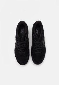 Černé sportovní boty z semiše a síťoviny, zaoblená špička, texturované detaily a zavazování na tkaničky. Logo viditelné na stélkách.