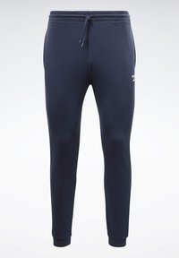 Mørkeblå sweatpants lavet af blødt stof, med drawstring i livet, tapered ben og en diskret logo detalje på låret.