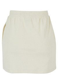 Falda de algodón elástico en color beige claro, con cinturilla elástica y bolsillos laterales; textura suave y una silueta recta y sencilla.