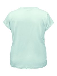 Jasnoniebieski luźny t-shirt z krótkim rękawem i okrągłym dekoltem, pokazany od tyłu, z małym białym napisem blisko kołnierza.