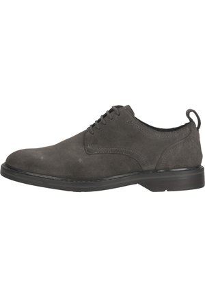 Zapato de vestir de ante gris con puntera redondeada, diseño de cordones y una superficie texturizada. Presenta una suela de goma negra y un pequeño tacón.