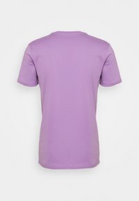 Lila kortärmad t-shirt i mjuk bomullstyg, med rund hals och en ren, enkel design.