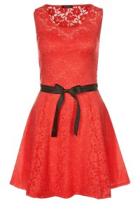 Robe rouge en dentelle sans manches avec un corsage ajusté, une jupe évasée et un ruban noir noué à la taille en nœud.