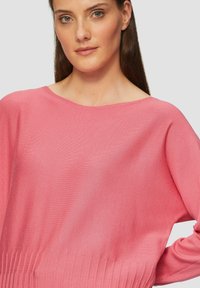 Roze trui met een wijde halslijn, geribbelde onderrand en zachte textuur. Beschikt over lange mouwen en een ontspannen pasvorm, ideaal voor casual kleding.