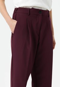 Bordeauxkleurige op maat gemaakte broek met plooien, voorzien van een gladde textuur, knoopsluiting en zijzakken, met een rechte pijp ontwerp.