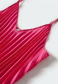Robe rose plissée sans manches avec fines bretelles et décolleté en V, posée à plat sur une surface blanche.