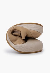 Scarpa slip-on beige con forma arrotondata. Presenta una texture morbida e un interno imbottito. Suola in gomma con superficie testurizzata per una migliore aderenza.