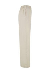 Beige avslappnade byxor med elastisk midja, sidslits, rak bendesign och mjukt bomullstyg.
