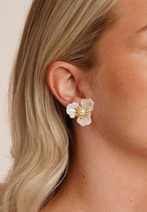 Blütenförmige Ohrringe aus weißem Material mit einer zentralen Perle und goldenen Perlenakzenten. Glatte Textur, stilvolles Design.